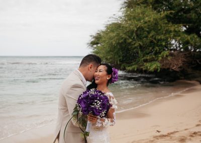 Nhu smiling on the beach while being hugged by her husband