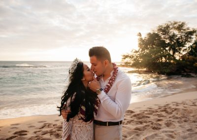 Nhu and her husband standing on a beach in their wedding clothes