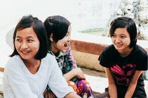 Three girls smiling together.