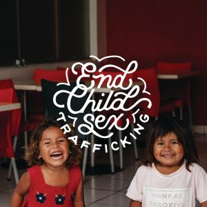 Two girls smiling next to text that says "End Child Sex Trafficking"