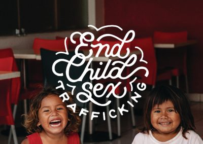 Two girls smiling next to text that says "End Child Sex Trafficking"