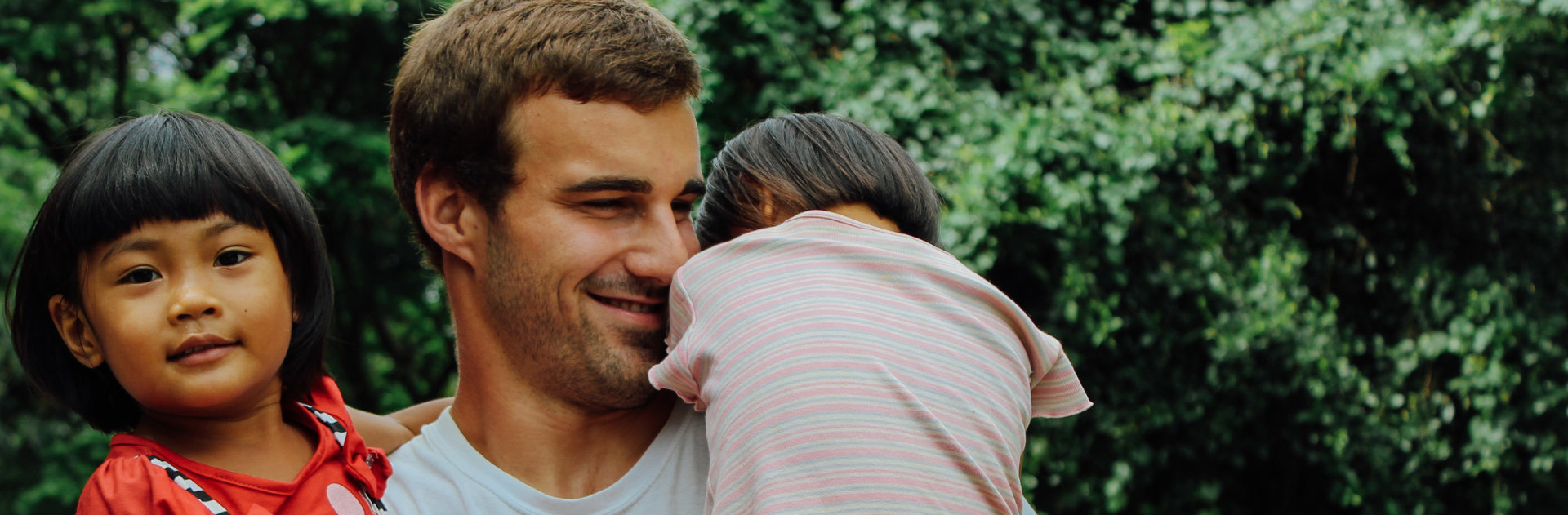 A man holding two children