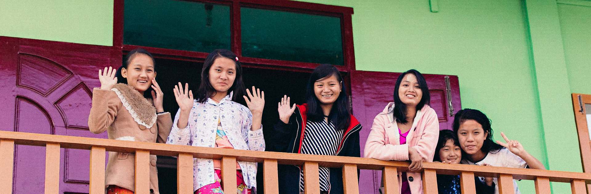 Girls waving on a balcony