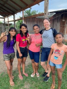 Erica standing with a group of young girls, who are all smiling.